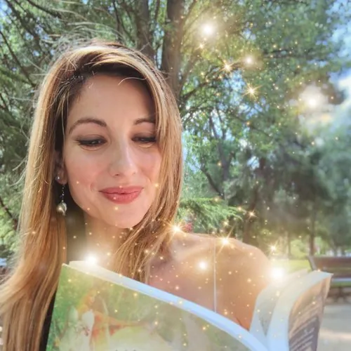 Irma leyendo un libro abierto, con destellos de luz
